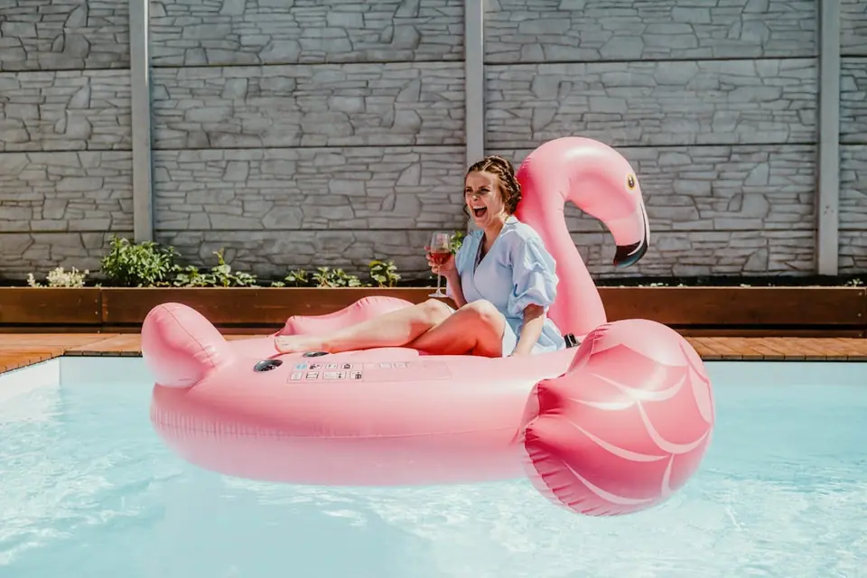 Woman in a sun hat relaxing at the edge of a pool